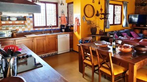 A cozy kitchen with wooden cabinets, a built-in oven, and a dining area with a table and chairs.