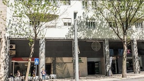 Un edificio moderno con facciata bianca, numerose finestre e un ingresso ben visibile.