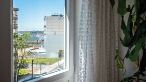 Vista dalla finestra su un edificio moderno, cielo sereno e un corpo d'acqua.