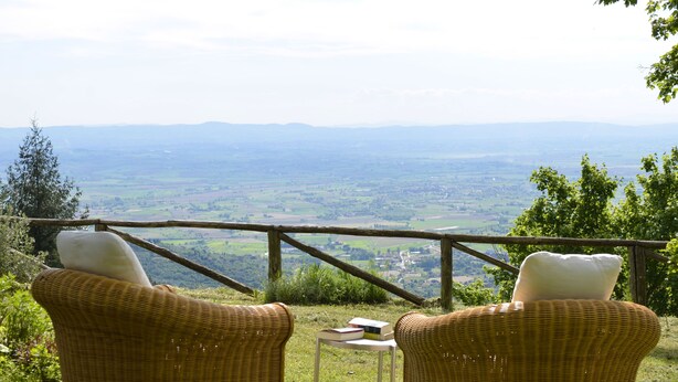 Two wicker chairs with cushions, a small table, and a view of a valley with distant mountains. - Belvedere House with panoramic views over the valley (Cortona)