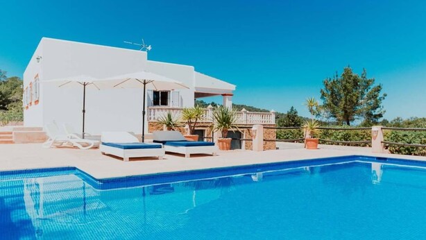 Eine moderne Villa mit Swimmingpool, Liegestühlen und einer Terrassenanlage.