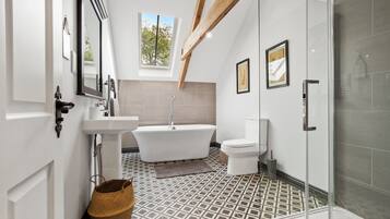 Bathtub, rainfall showerhead, hair dryer, towels