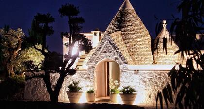 Un ancien trullo avec piscine nichée avec vue sur une magnifique vallée privée