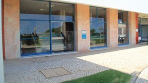 Um edifício com grandes portas de vidro, área de entrada com azulejos e uma placa indicando 'Concordia'.