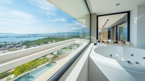 A modern bathroom with a large bathtub, a view of a coastal landscape, and a glass-enclosed balcony. - VILLA HILLTOP (Nuestra Sra de Jesus)