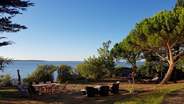 An outdoor seating area with chairs and tables, a hammock, and a view of the water. - Superb Basque villa. Direct access to the sea. 7 bedrooms including 4 doubles. 12/13 p (La Tremblade)