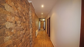 A hallway with stone walls and wooden flooring, leading to a door at the end. - House with private pool near Gerês (Terras de Bouro)