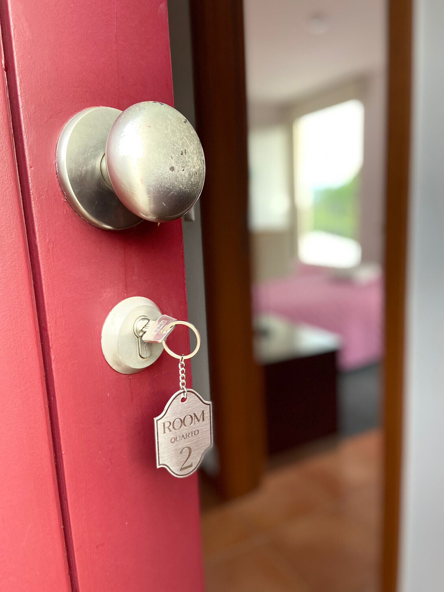 Une porte avec un porte-clés indiquant « CHAMBRE 2 » et un trou de serrure.