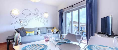 Relax in a stylish room with a sofa, dining table, and TV, offering a comfortable seating area and beautiful views.