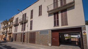 A multi-story building with a ground-level entrance, a balcony, and a visible garage door. - LOVELY POOL APARTMENT with PARKING 3 (Tossa de Mar)