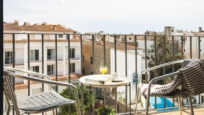 A balcony with a table, chairs, and a glass of orange juice. - LOVELY POOL APARTMENT with PARKING 3 (Tossa de Mar)