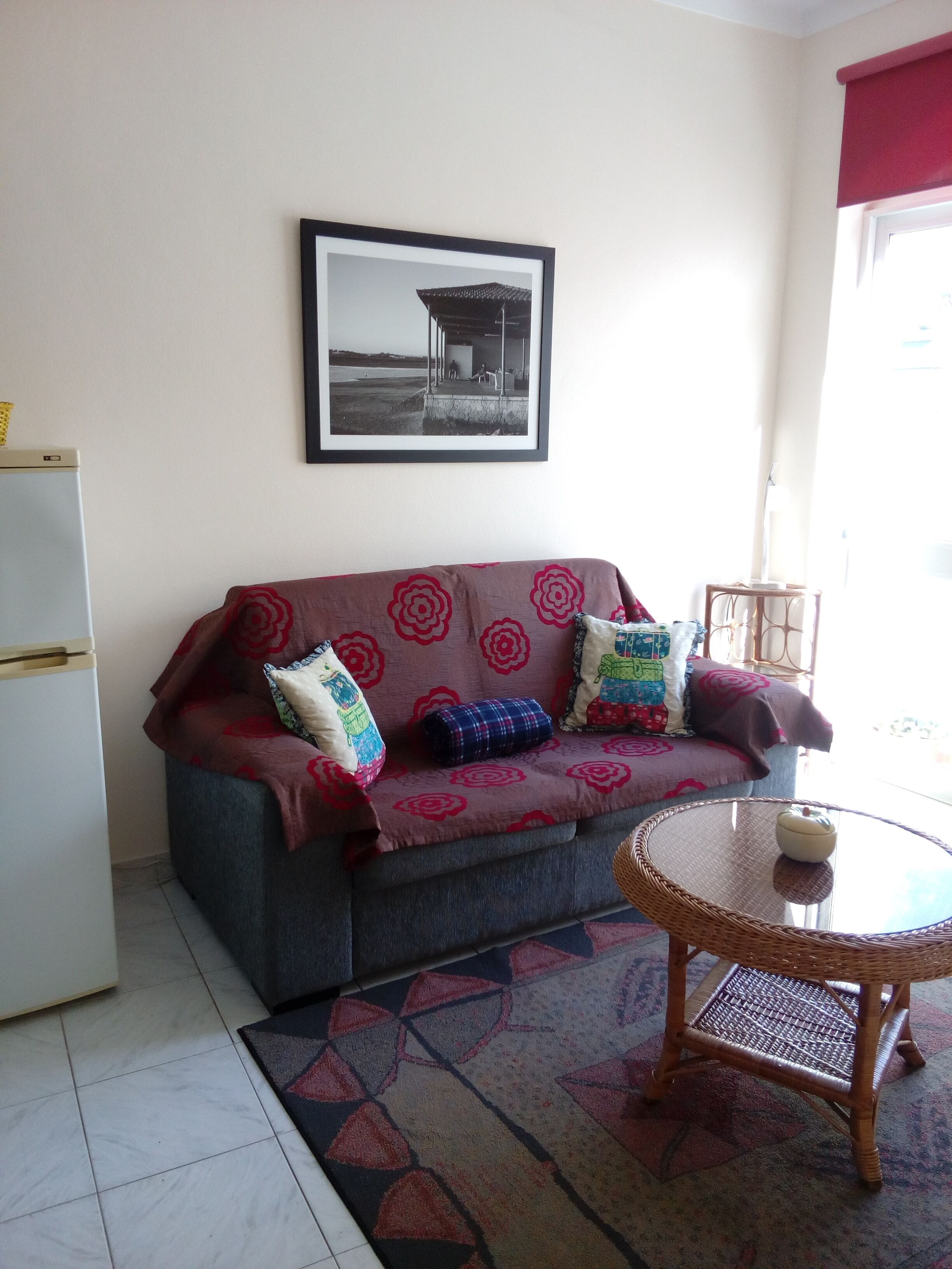 A living room with a sofa, a small table, and a framed picture on the wall.