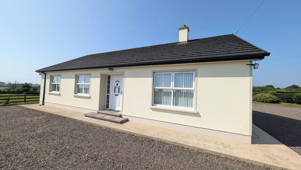 A single-story house with a gabled roof, a front door, and two windows. - Charming 3 Bedroom, Self Catering in centre of Mid Ulster close to Cookstown (Rock Dungannon)