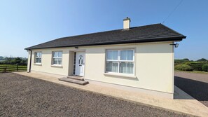 A single-story house with a gabled roof, a front door, and two windows. - Charming 3 Bedroom, Self Catering in centre of Mid Ulster close to Cookstown (Rock Dungannon)