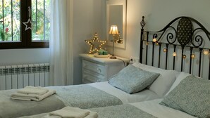 A bedroom with a bed, bedside tables, a dresser, a mirror, and a window with curtains. - OLIVILLAS GARDEN - BASE POINT ACCESS SIERRA NEVADA AND GRANADA (Güejar Sierra)