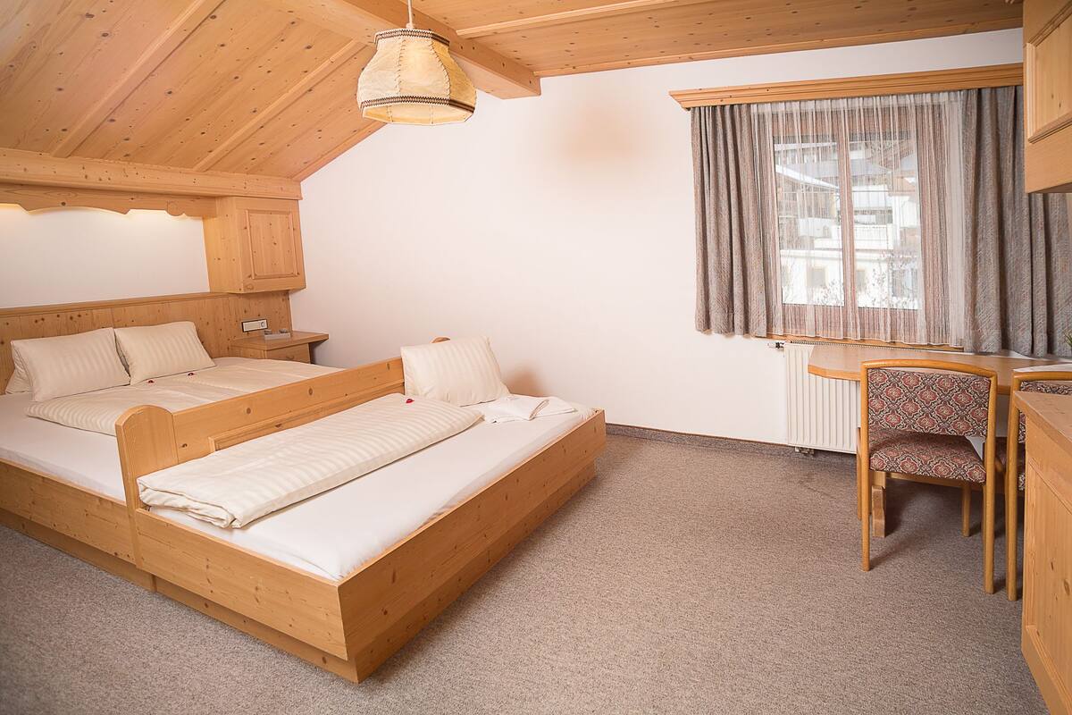 Une chambre à coucher en bois, avec un lit, une table de chevet et une chaise.