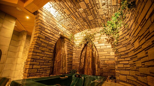 A stone-walled spa area with a hot tub and seating. - Panzl braü (Virgen)