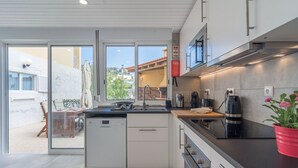 Eine moderne Küche mit Geschirrspüler, Kaffeemaschine und Mikrowelle.