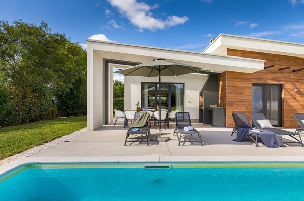 A modern house with a pool, outdoor seating, and a barbecue area. - Villa Sama - Beautiful modern built villa with pool in Central Istria (Zminj)