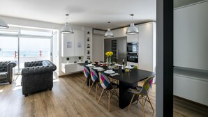 Une cuisine moderne avec un îlot central noir, des armoires blanches et des luminaires suspendus.