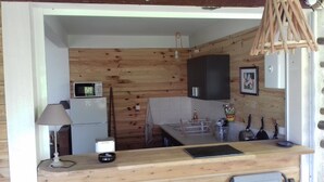 A compact kitchen with wooden paneling, a microwave, a refrigerator, and basic amenities. - Kay Zanndoli, sea view, pool, jacuzzi, garden (La Trinité)