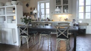 Una cocina rústica con sillas de madera, una isla central y armarios blancos.