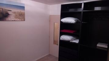 Une pièce comprenant un lit, une armoire et un tableau accroché au mur.