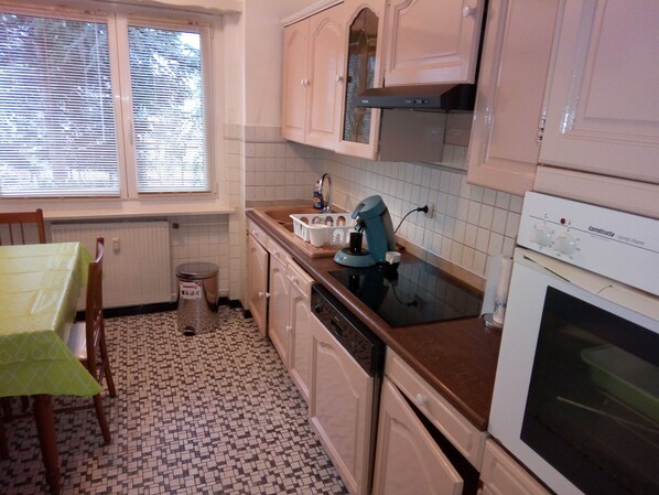 A kitchen with a window, a sink, a coffee maker, and a stove.
