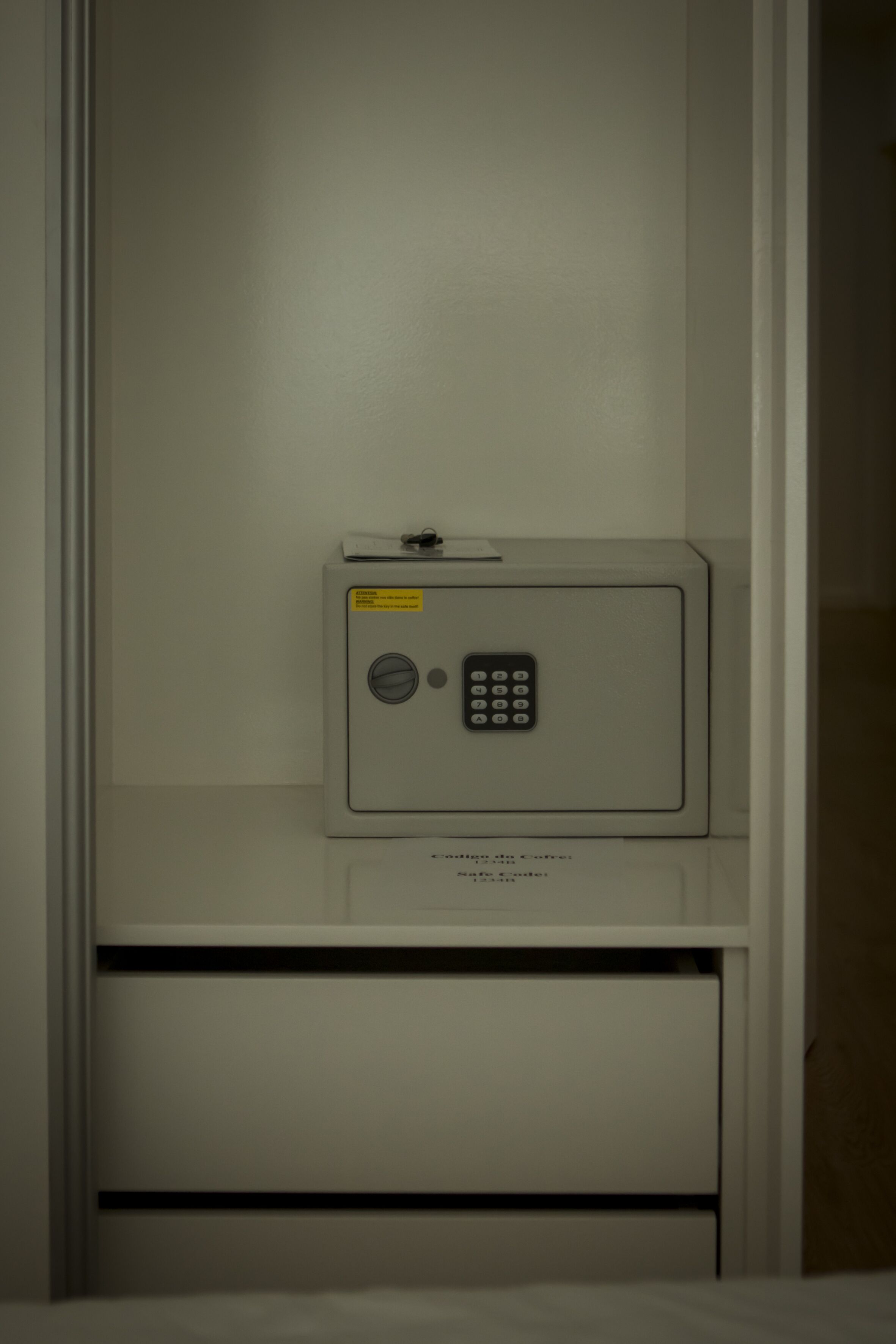 A safe deposit box in a room with a white interior and a metal door.