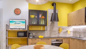 Una cucina moderna con un tavolo rotondo, sedie gialle e un forno integrato.