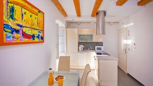 Une cuisine moderne avec des armoires blanches, une hotte de cuisinière en acier inoxydable et un four à micro-ondes.