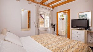 Une chambre d’hôtel équipée d’un lit, d’une télévision, d’un bureau et d’un miroir.