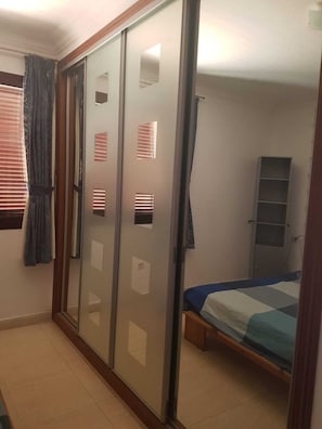Une chambre à coucher comprenant un lit, une armoire et une étagère.