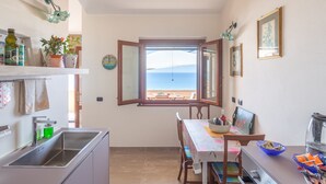 Una cocina con vista al mar, una mesa de comedor y un ventanal.