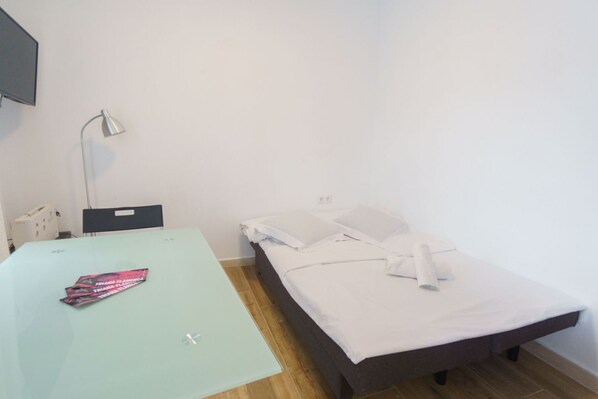 A room with a bed, a desk, and a lamp. - RentalSevilla Enladrillada Center City (Sevilla)
