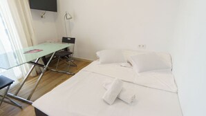 A hotel room with a bed, a desk, and a chair. - RentalSevilla Enladrillada Center City (Sevilla)