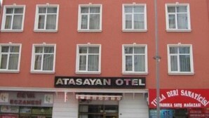 Un edificio rojo con varias ventanas y un letrero que dice "ATASAYAN OTEL".