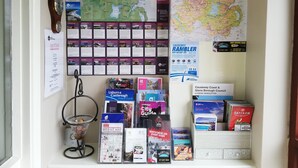 A wall with various travel guides, maps, and informational posters.