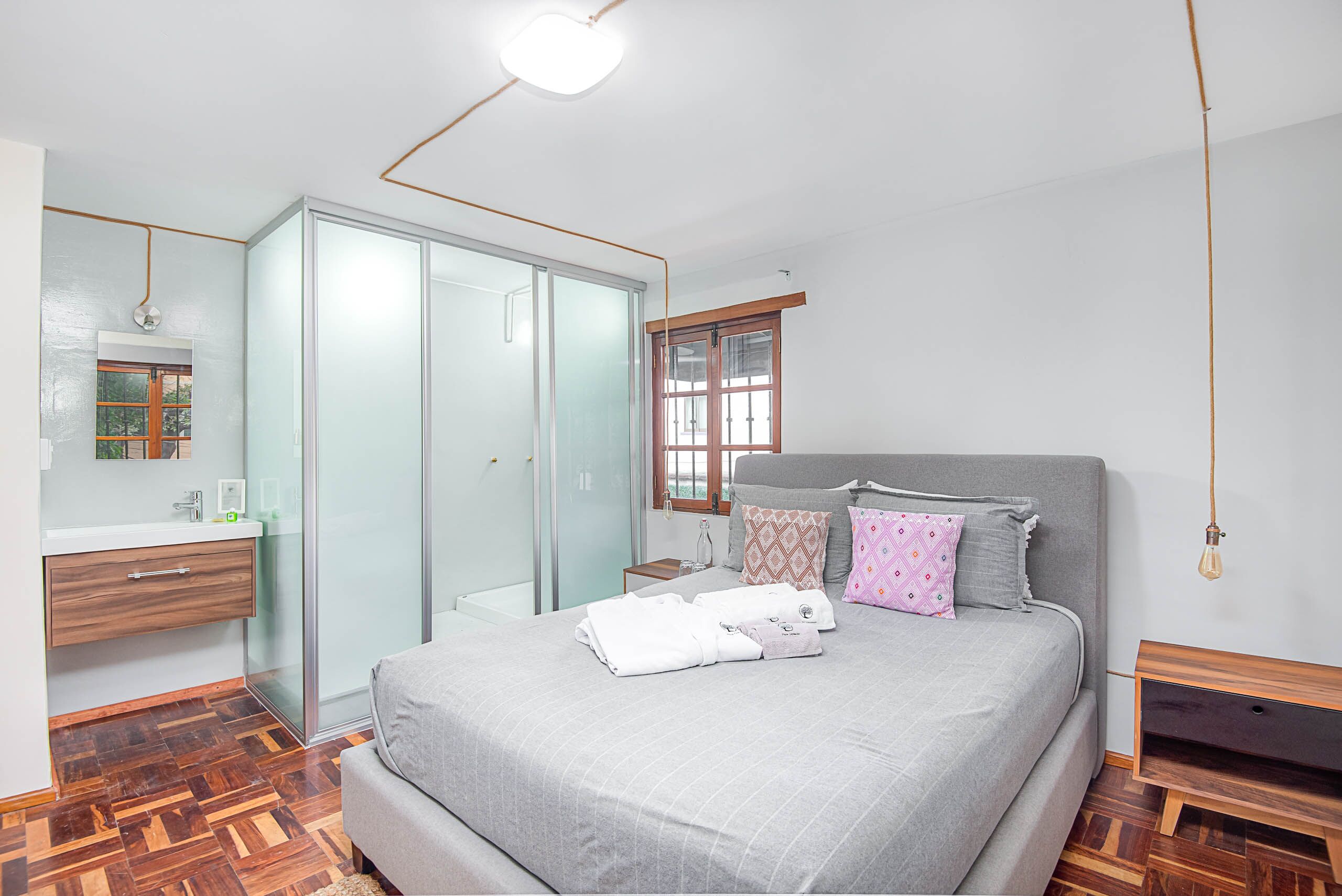 A bedroom with a bed, bedside table, and a wardrobe.