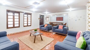 Un salón amplio con un gran ventanal, un comedor y una cocina al fondo.