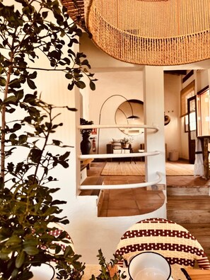 A room with a hanging chair, a dining area with a table and chairs, and a staircase. - Nice house with pool in a quiet area. (San Francisco Javier)