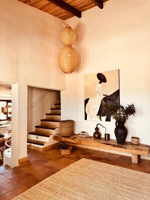A staircase with a woven basket, a painting of a woman, and a vase with plants. - Nice house with pool in a quiet area. (San Francisco Javier)