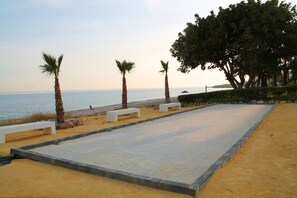 Een strand met palmbomen, banken en een helder uitzicht op de zee.