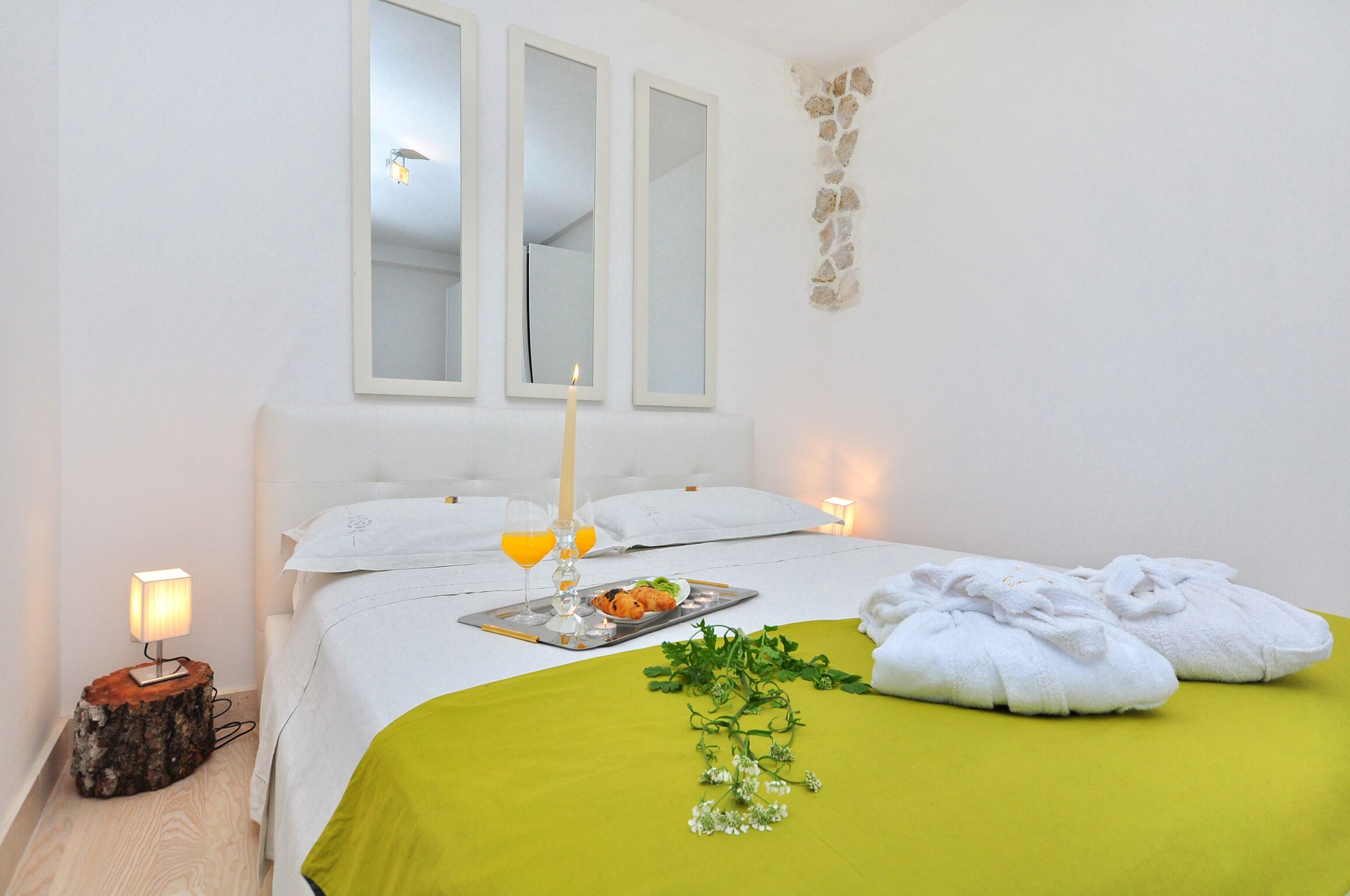 Una camera d'albergo ordinata con un letto, un comodino e un vassoio con articoli per la colazione.