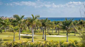 Un parcours de golf bordé de palmiers, avec vue sur l’océan.