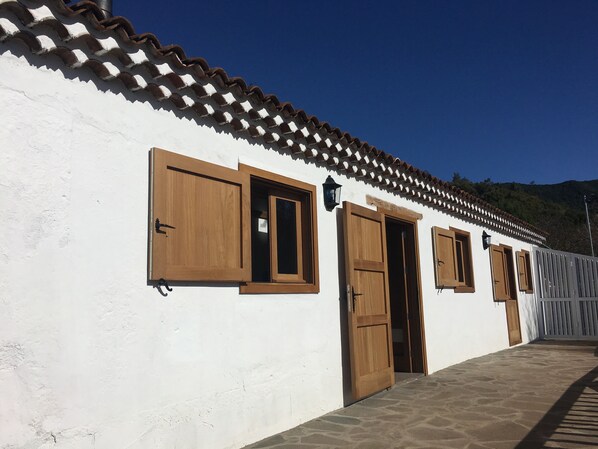 Un edificio bianco con tetto in tegole e porte e finestre in legno.