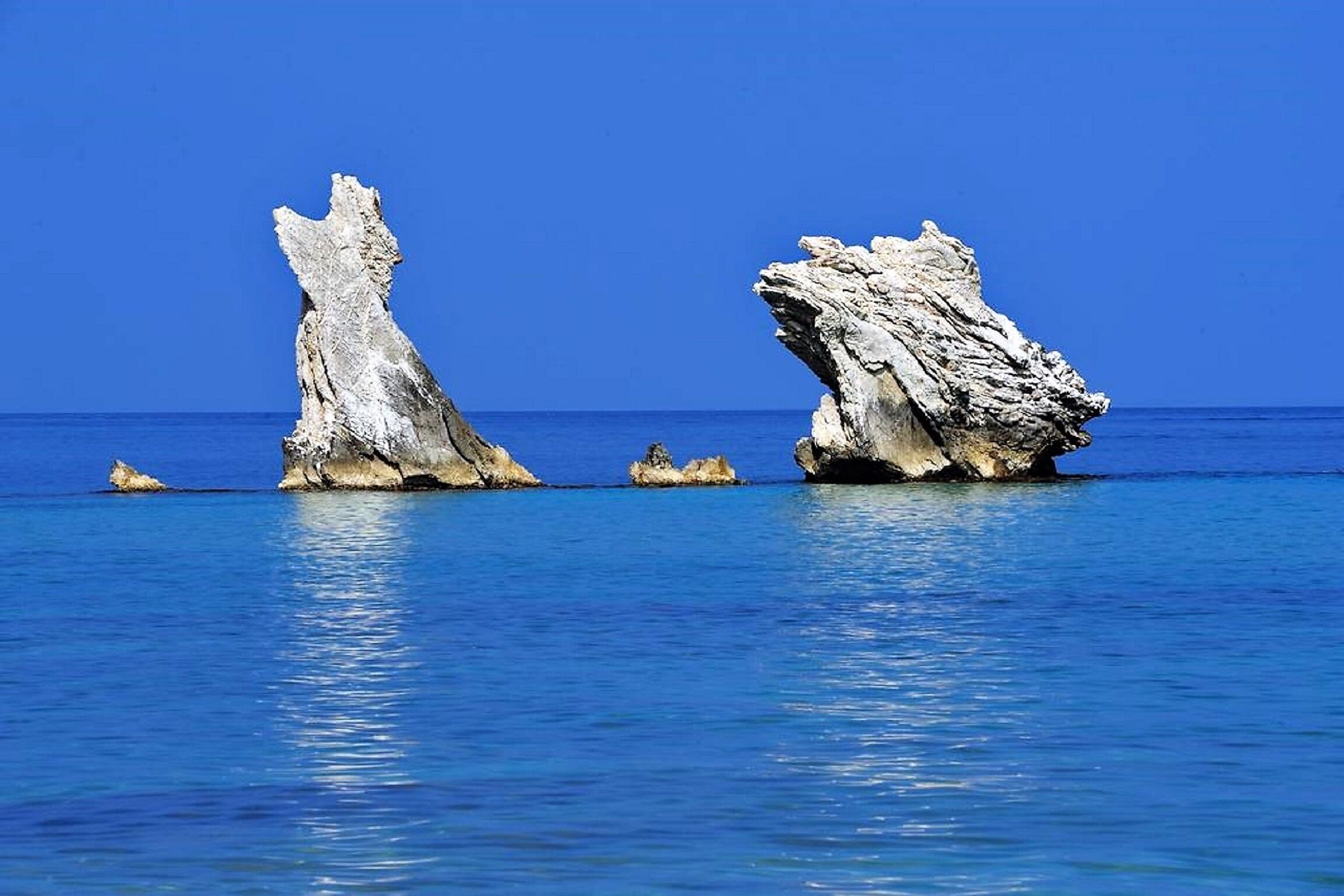 A clear view of a coastal rock formation with a calm sea in the background.