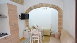 A compact living space with a kitchenette, a dining area, and a seating area.