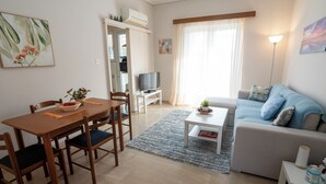 A living room with a dining table, sofa, and TV. - Appartment 51 sq.m / Sandy beach + Int. Airport (Saronida)