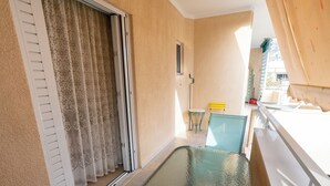 A balcony with a glass table, a chair, and a small table with a yellow chair. - Appartment 51 sq.m / Sandy beach + Int. Airport (Saronida)